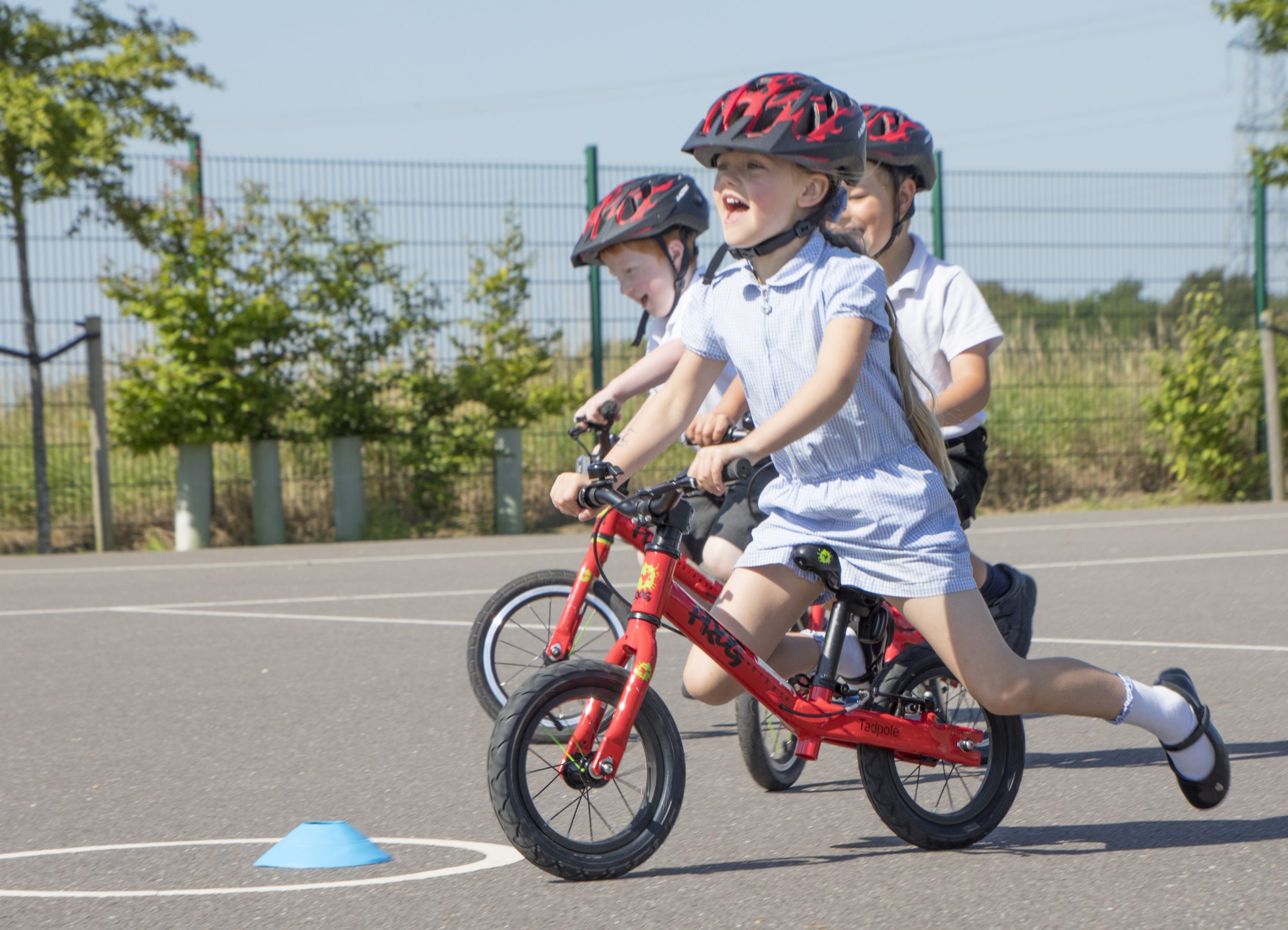 A young girl rides a balance bike