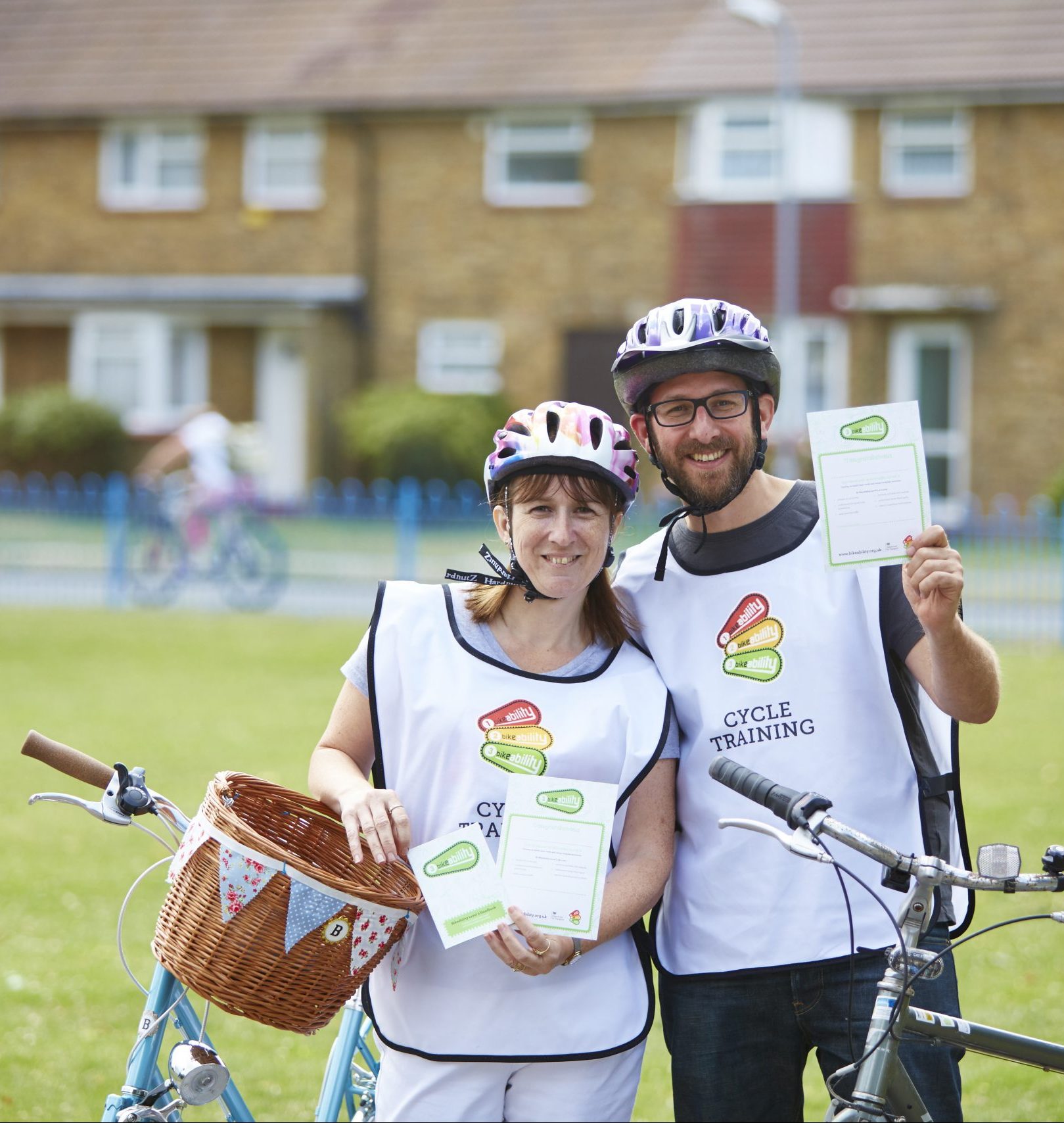 A man and a woman holding Bikeability certificates