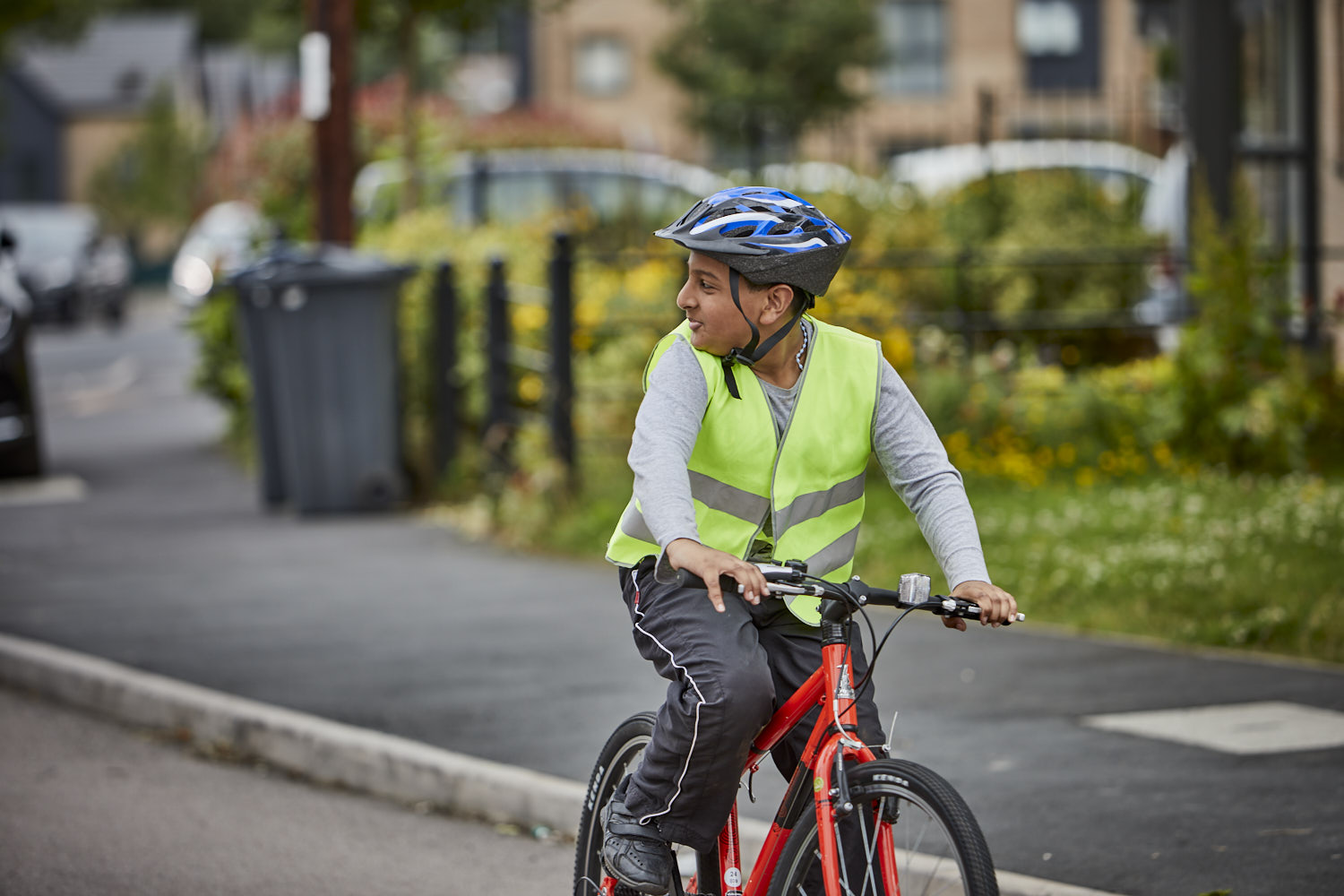 Young boy on a bike checking for cars behind him